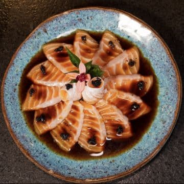 Carpaccio Barriga de Salmão — Lâminas finas de barriga de salmão condimentado com molho ponzu e azeite